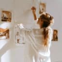 A woman pinning layout sketches to a studio wall